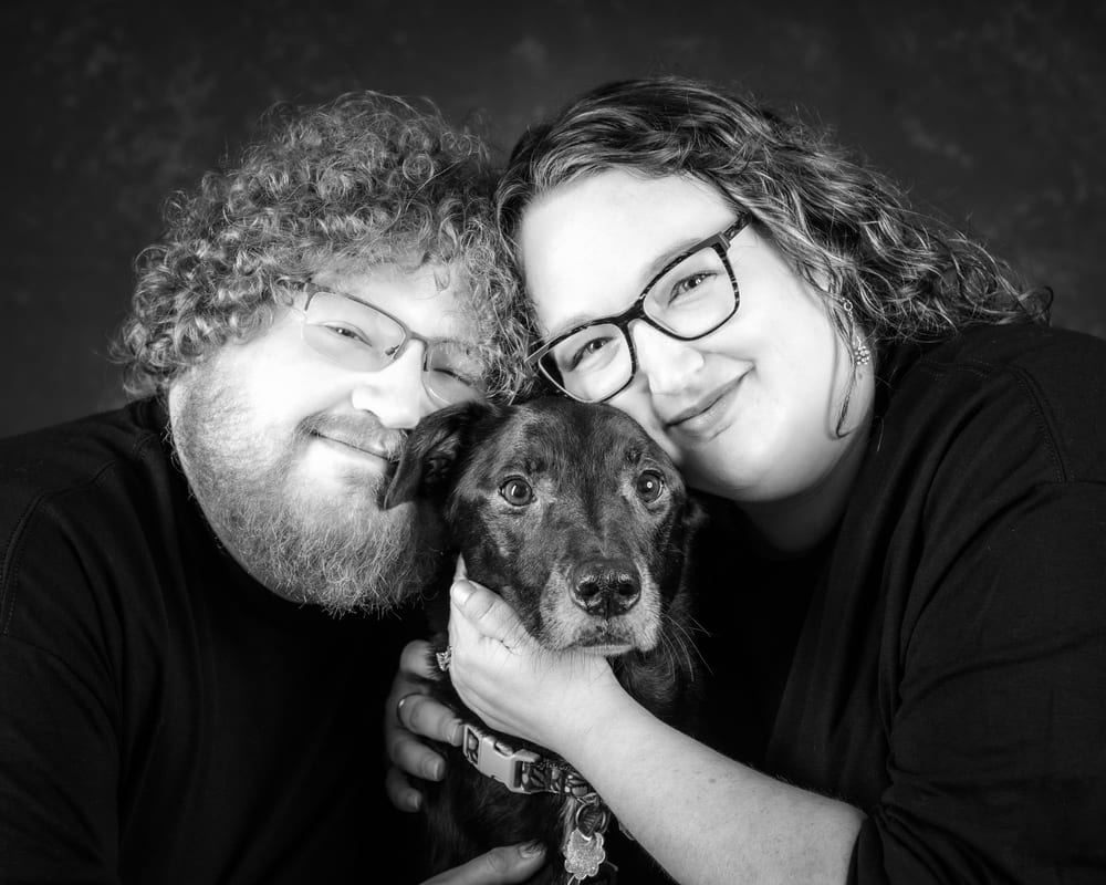 Lauren and her partner with their black dog