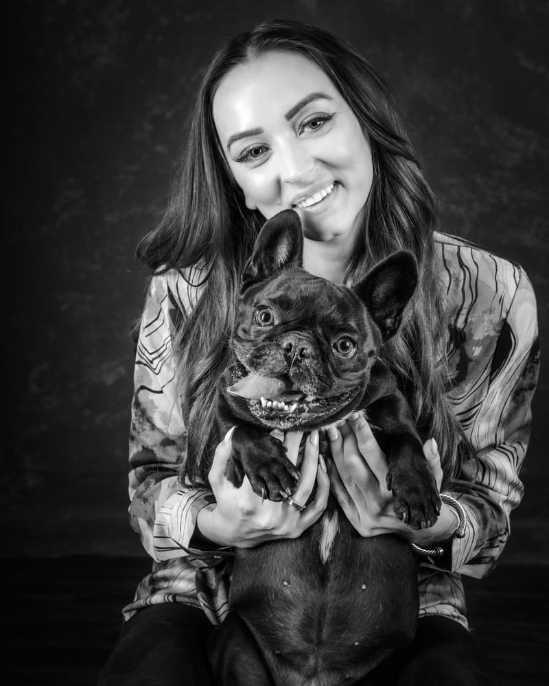 Victoria smiling with her Frenchie in her arms